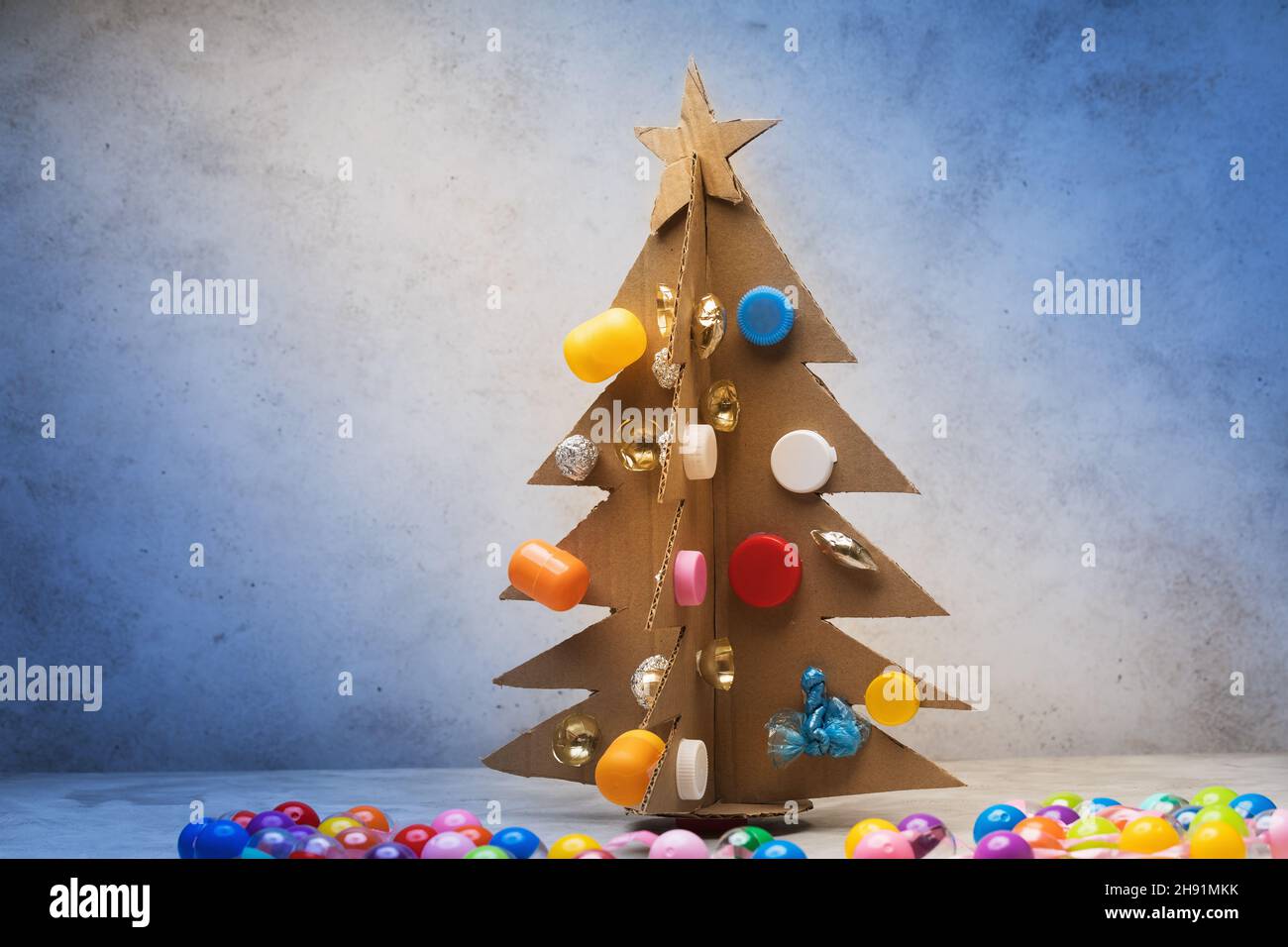 Christmas tree made of cardboard, decorated with recycled materials on