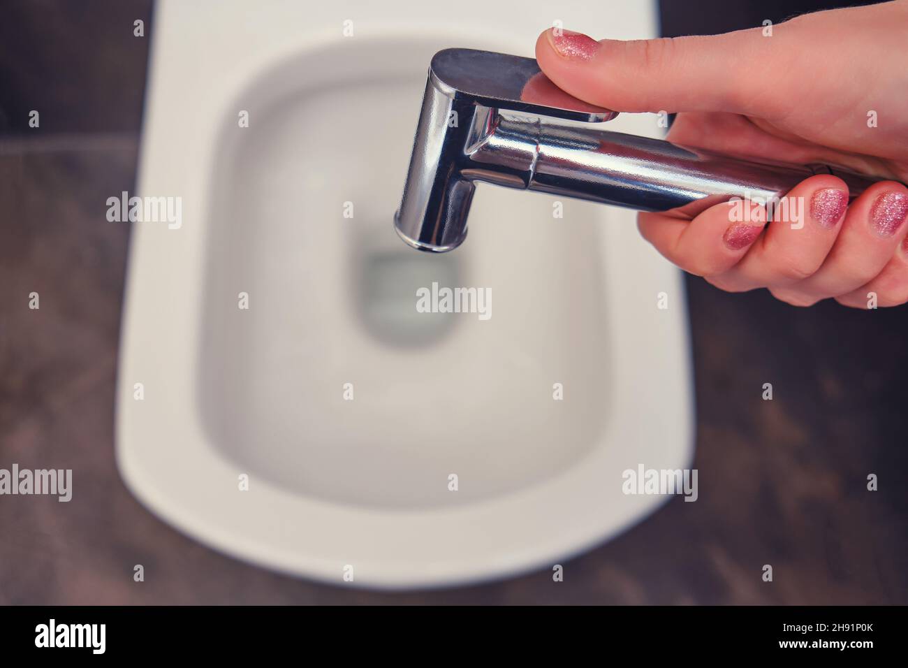 Hygienic shower in a woman hand, closeup on the background of the