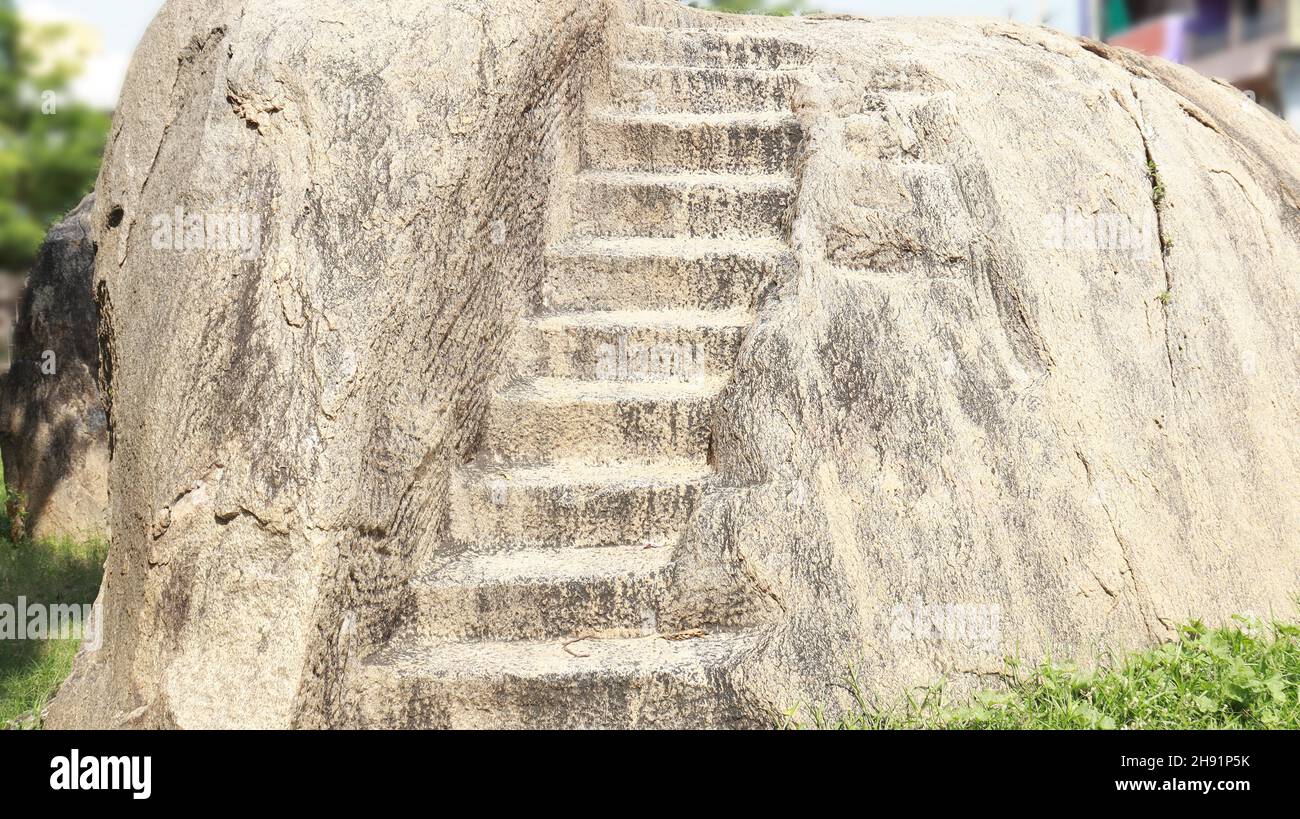 Stairs carved into the rock. Located on a rocky and dim background ...