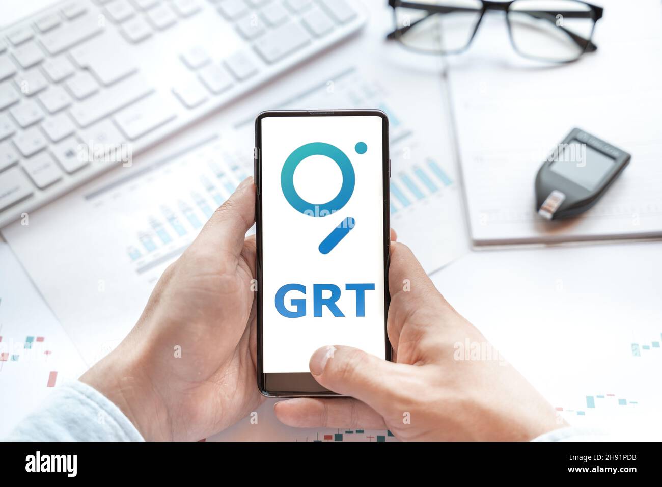 Logo of Graph coin in tablet. Cryptocurrency GRT token. Trading blockchain platform to buy,sell on decentralized exchange DEX,DEFI. Digital money.Busi Stock Photo