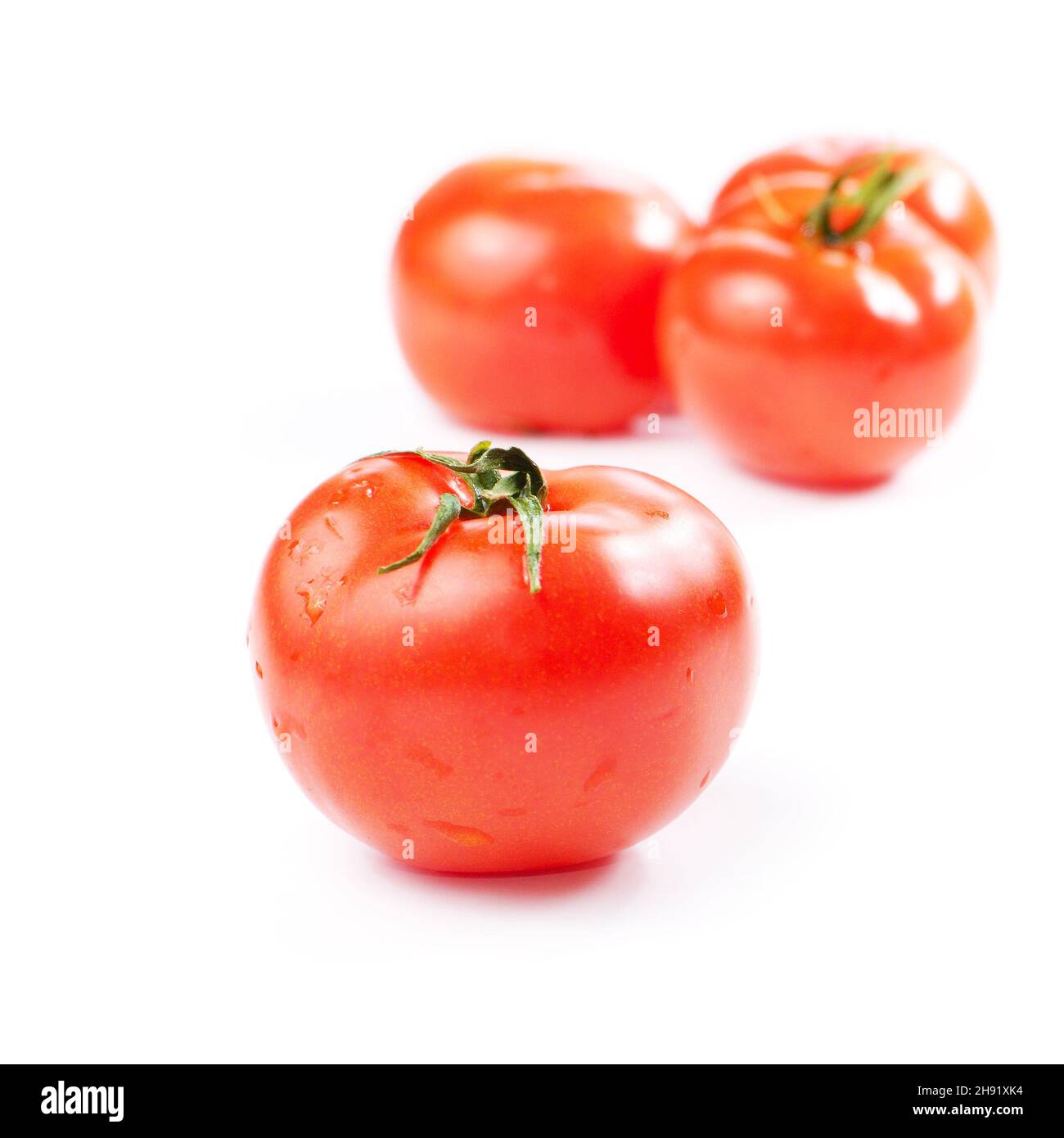 Three fresh tomatoes isolated on white background Stock Photo - Alamy