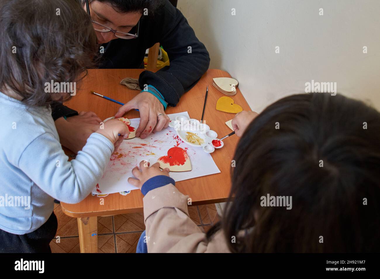 Mother and two children painting hearts. Valentine's Day Stock Photo
