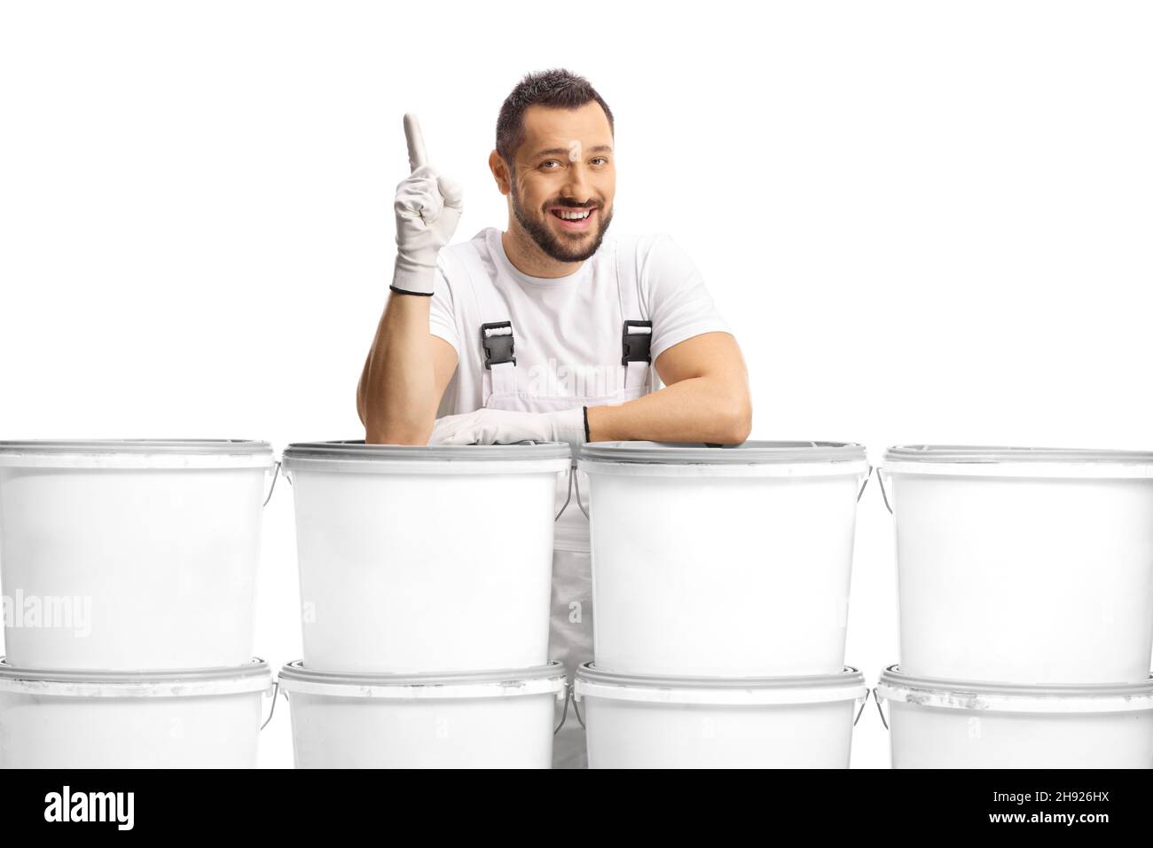 House painter leaning on a pile of color buckets and pointing up ...