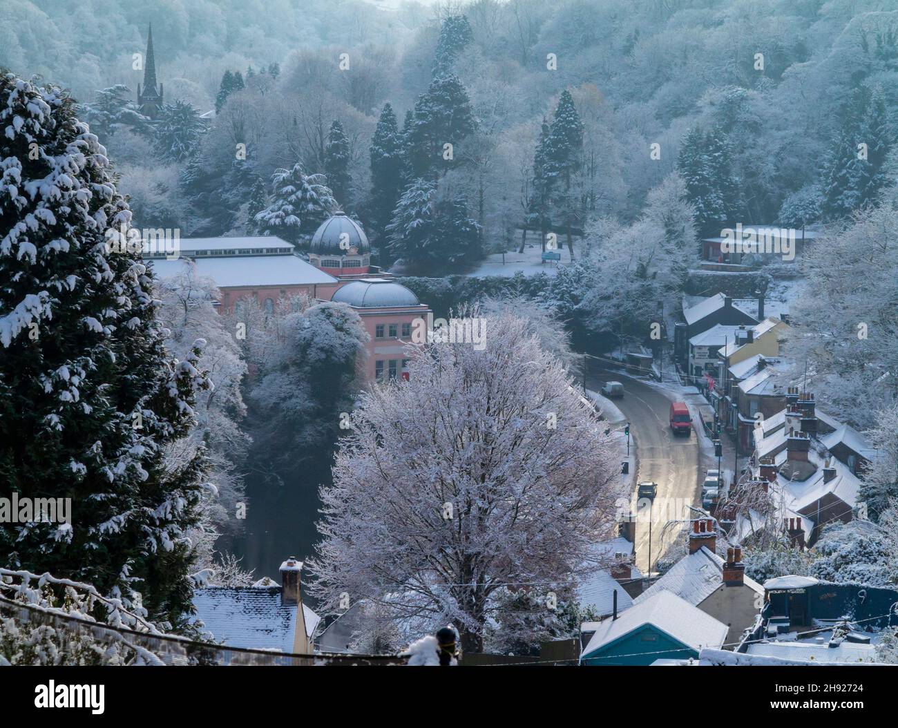 Snow covered landscape with trees at Matlock Bath in the Derbyshire Peak District England UK with traffic on the A6 road visible. Stock Photo