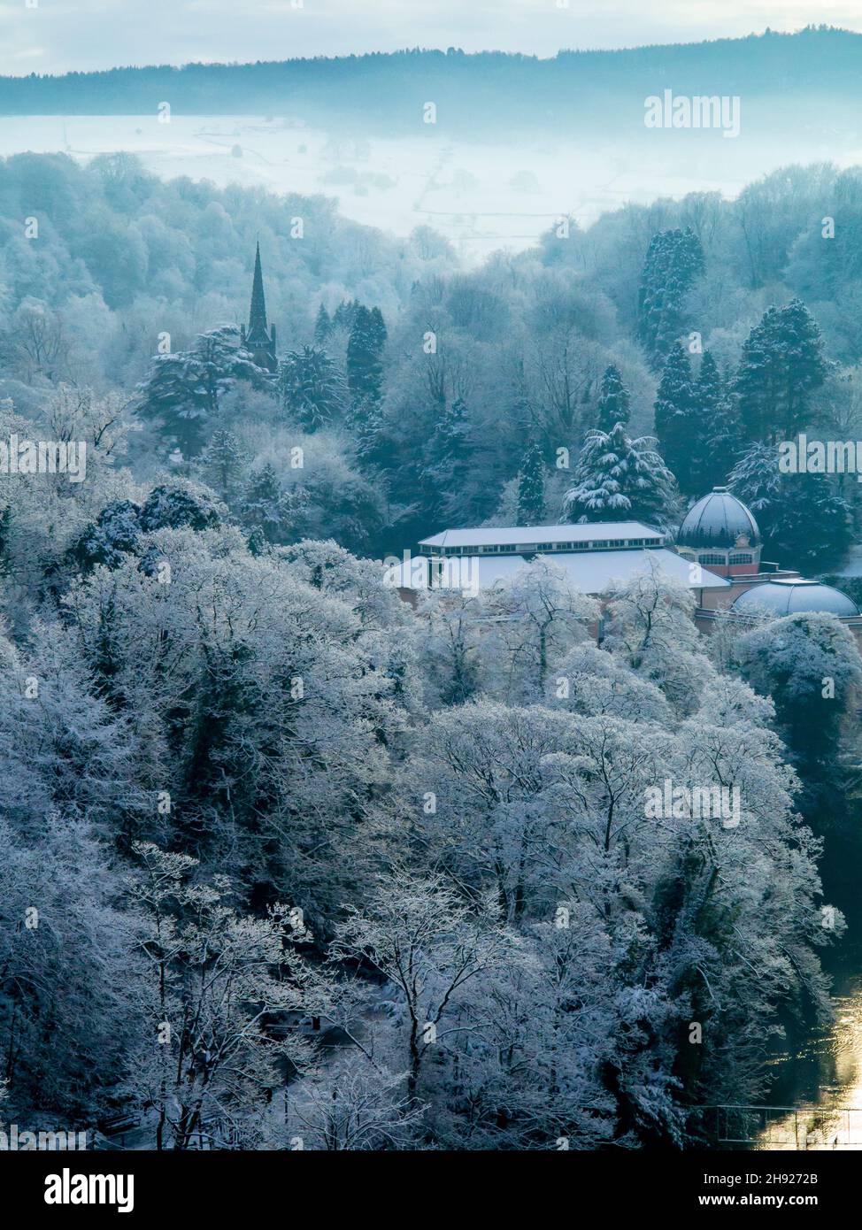 Snow covered landscape with trees at Matlock Bath in the Derbyshire Peak District England UK with Cromford Moor visible in the distance. Stock Photo