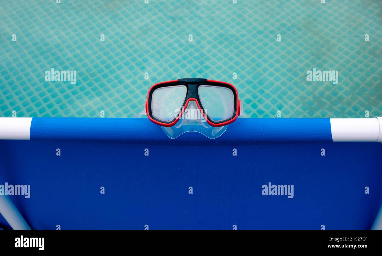 Swimming goggles used in swimming training hang on the side of the pool