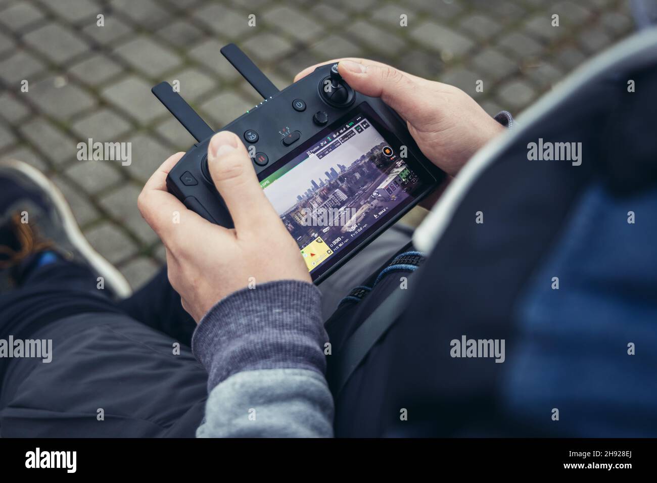 Man holds remote controller of DJI Mavic 2 Pro drone Stock Photo