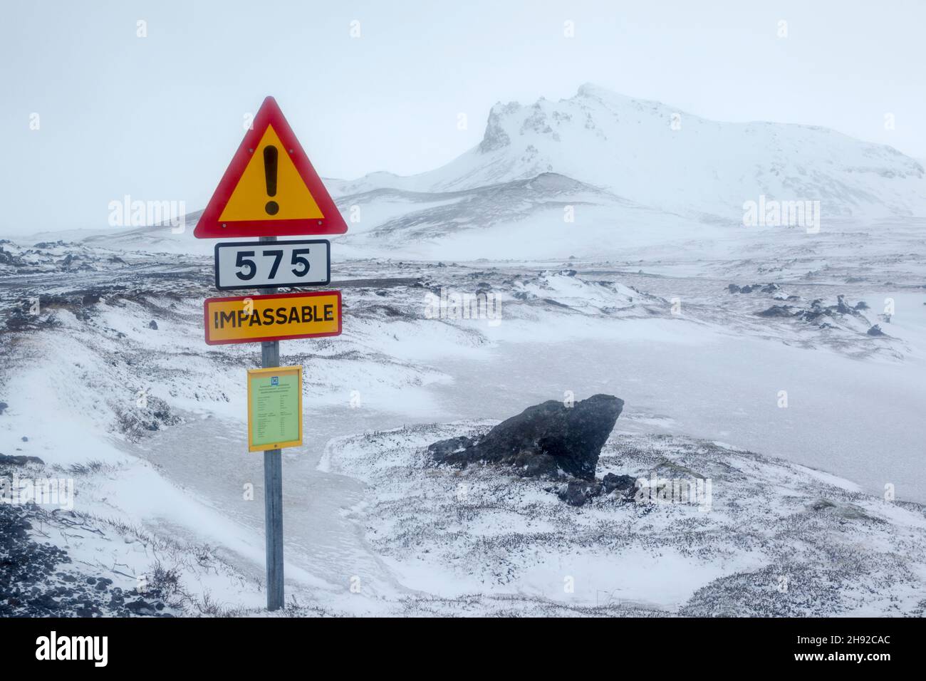 Winter view towards the mountain of Hreggnasi on the Snæfellsnesnes peninsula in the Western part of Iceland with a warning sign showing that the road Stock Photo
