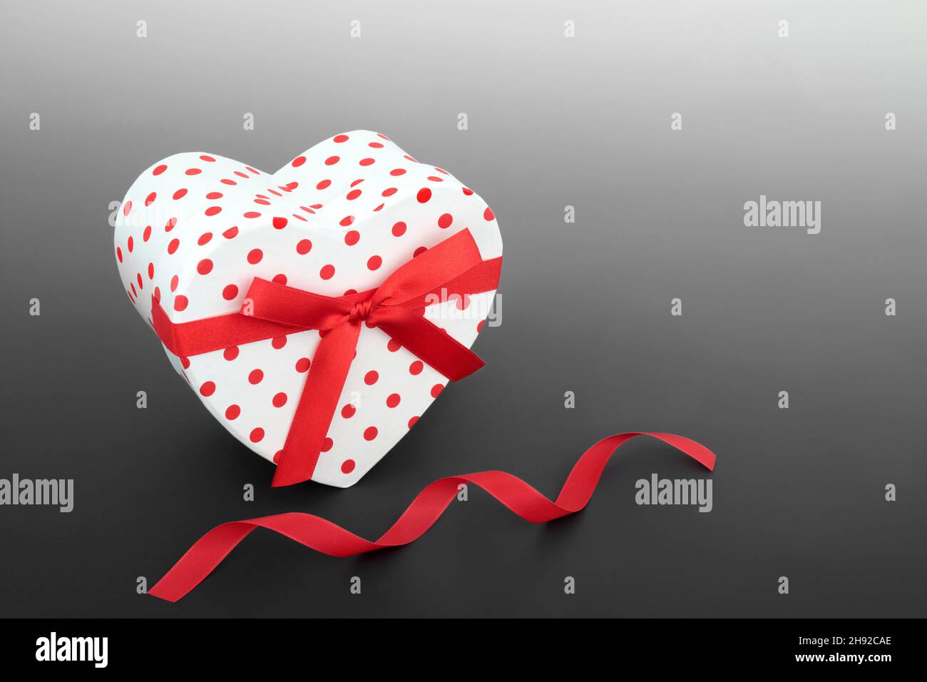 Happy Valentines Day polka dot heart shaped gift box with red bow and ...
