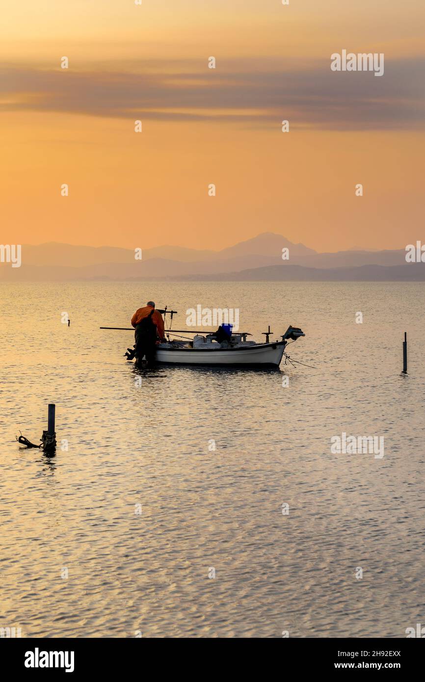 A fisherman prepares his boat in the sea to fish Stock Photo