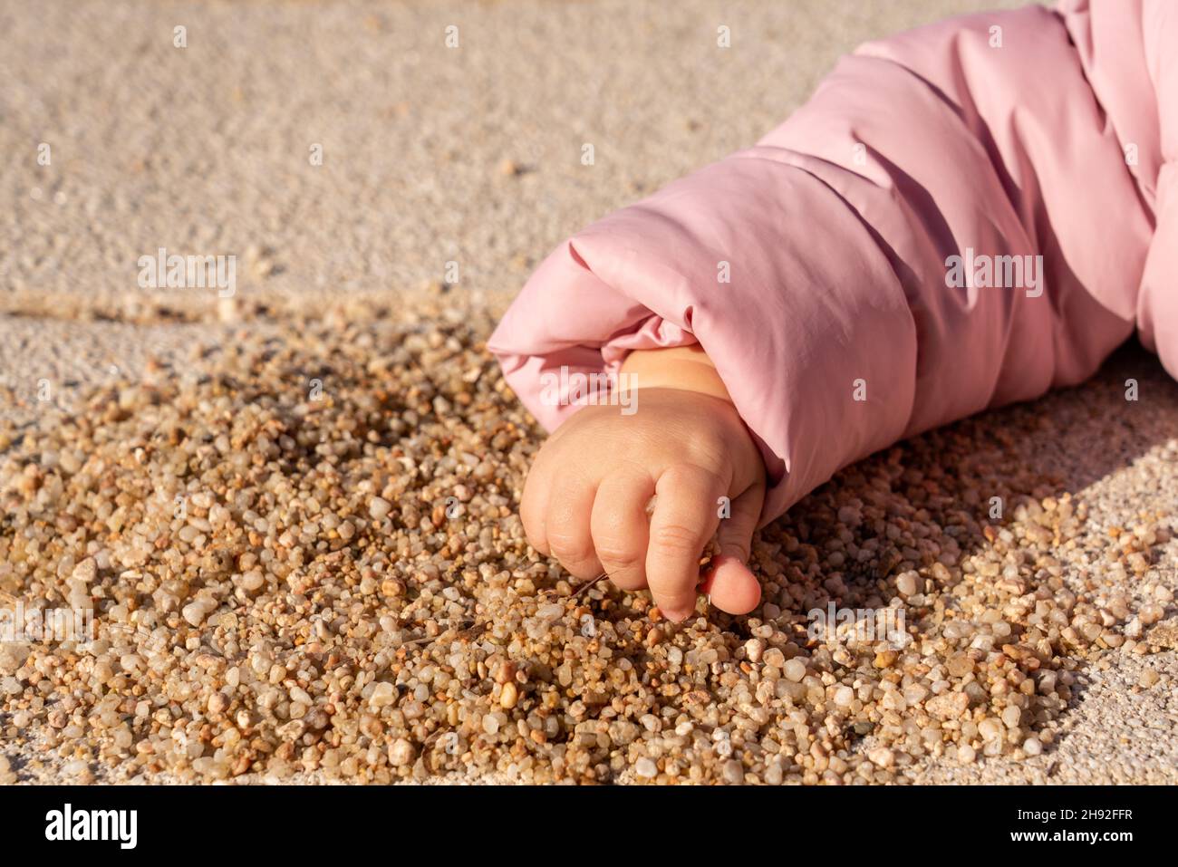 children's hand takes a handful of sand Stock Photo