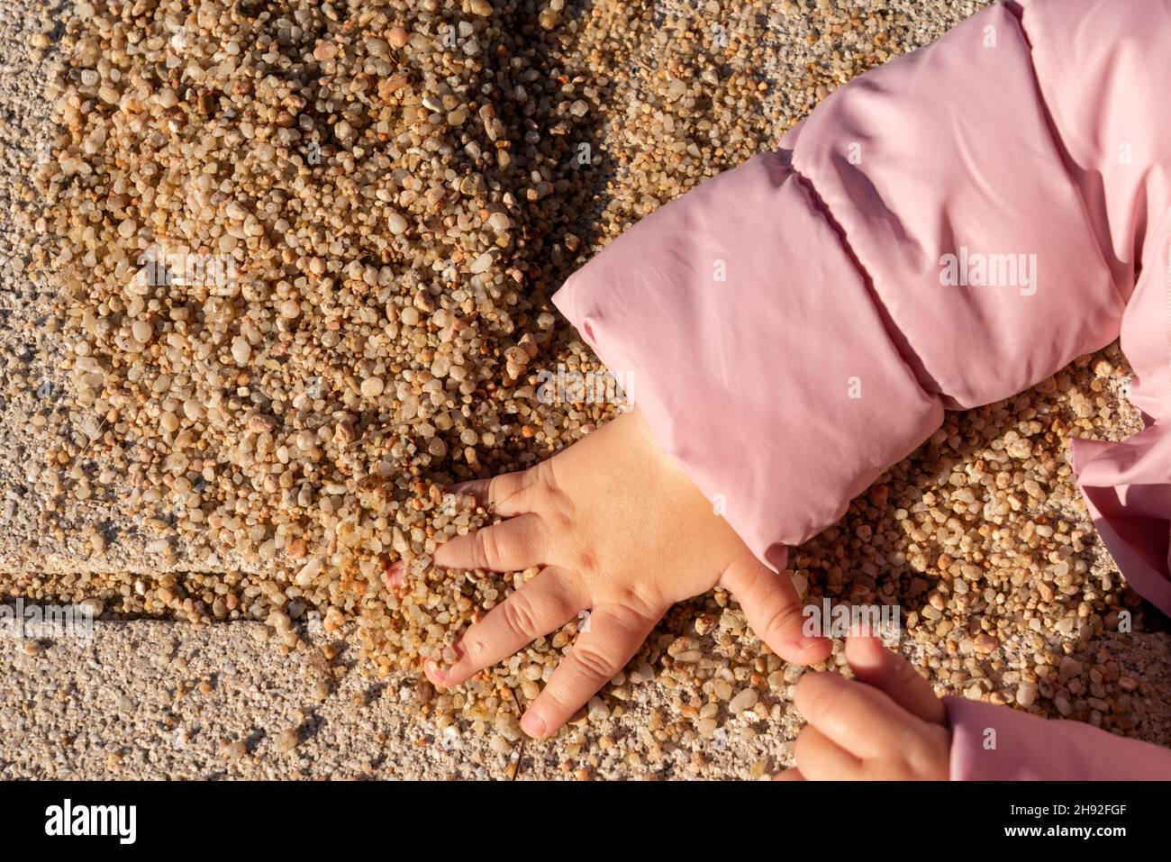 children's hand takes a handful of sand Stock Photo