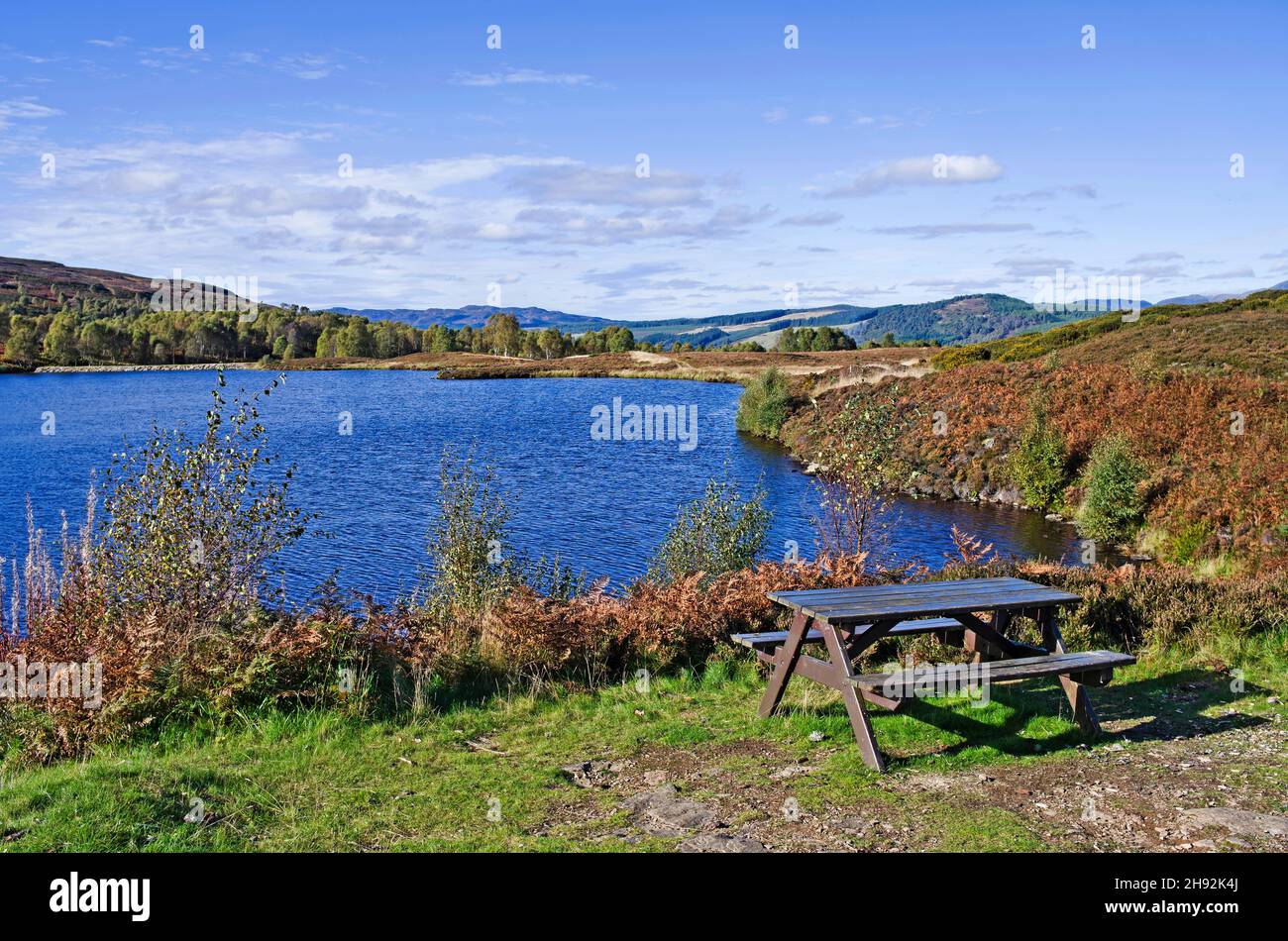 Picnic table by small upland loch on moorland, early autumn, Highland Perthshire, Scotland UK Stock Photo