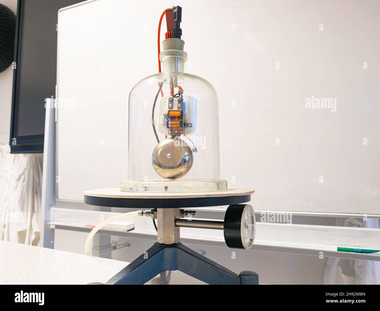 Electric bell under a bell jar where the air is vacuumed through a hose