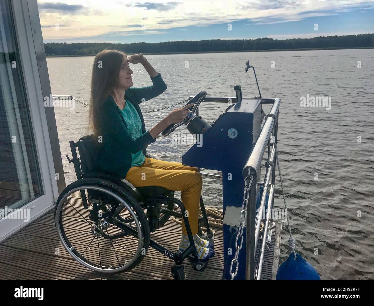 Frau im Rollstuhl steuert Hausboot Stock Photo