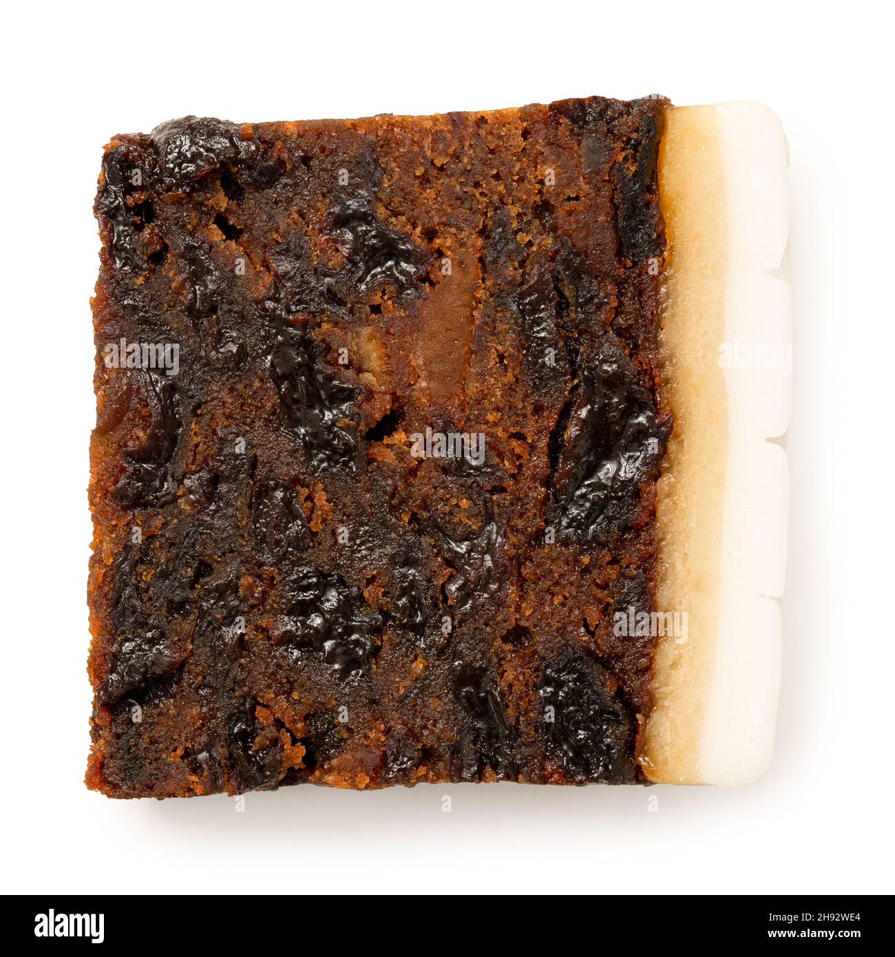 Slice of iced fruit cake isolated on white. Top view. Stock Photo