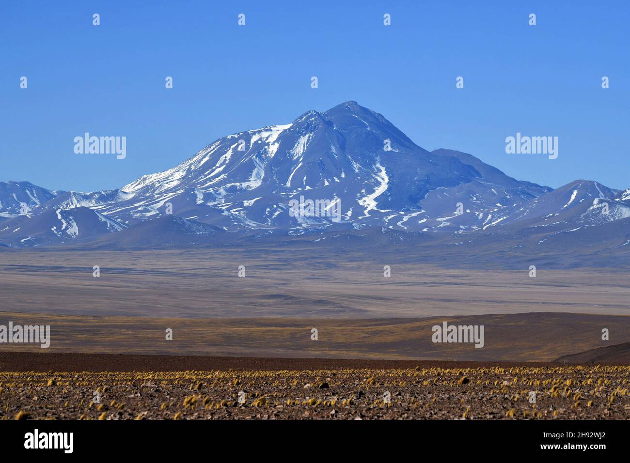 Mountainscape with a volcano across the dry open terrain in Atacama desert, Northern Chile Stock Photo
