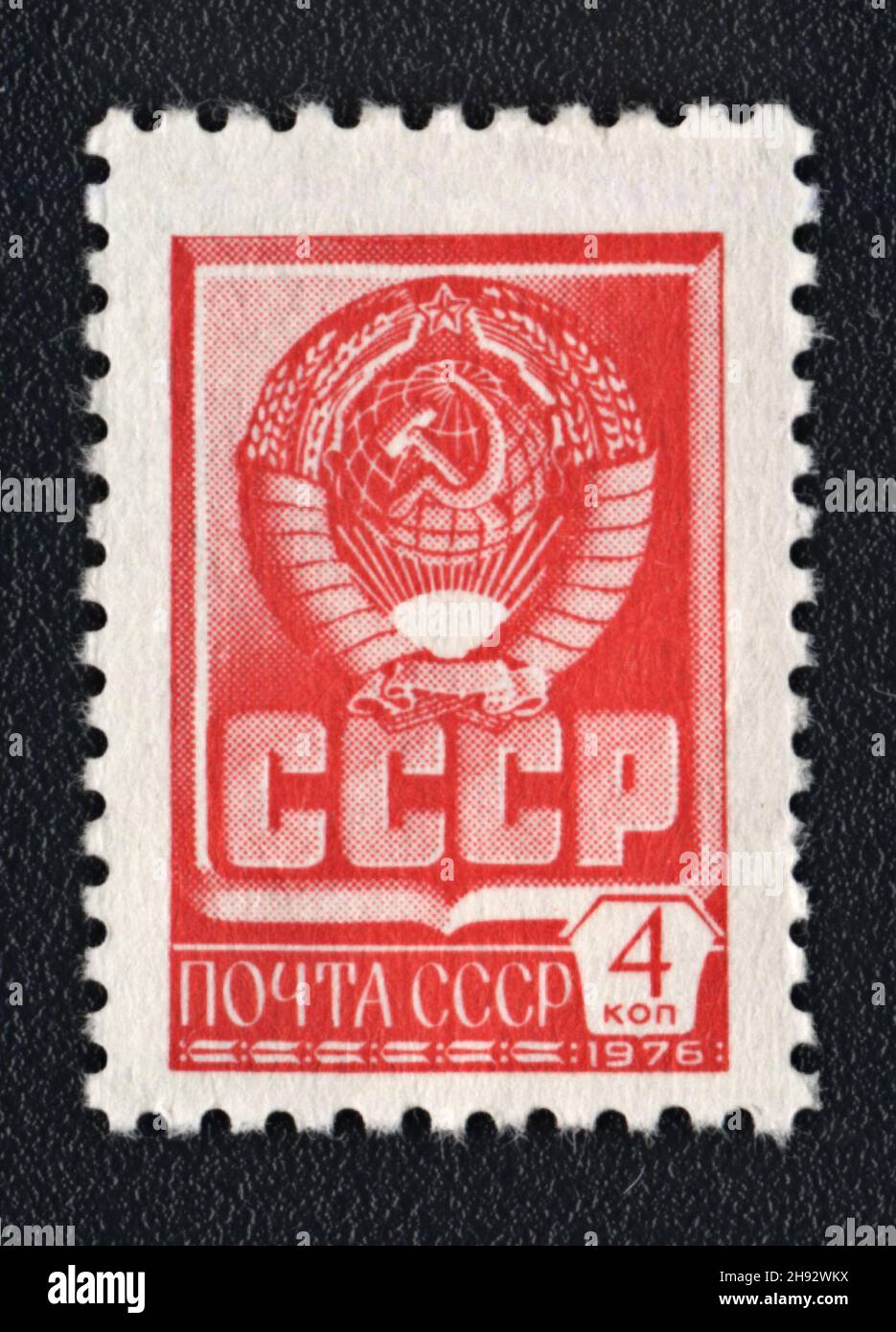 A postage stamp printed in USSR shows Red State Emblem and red flag of the Soviet Union, 1976 Stock Photo