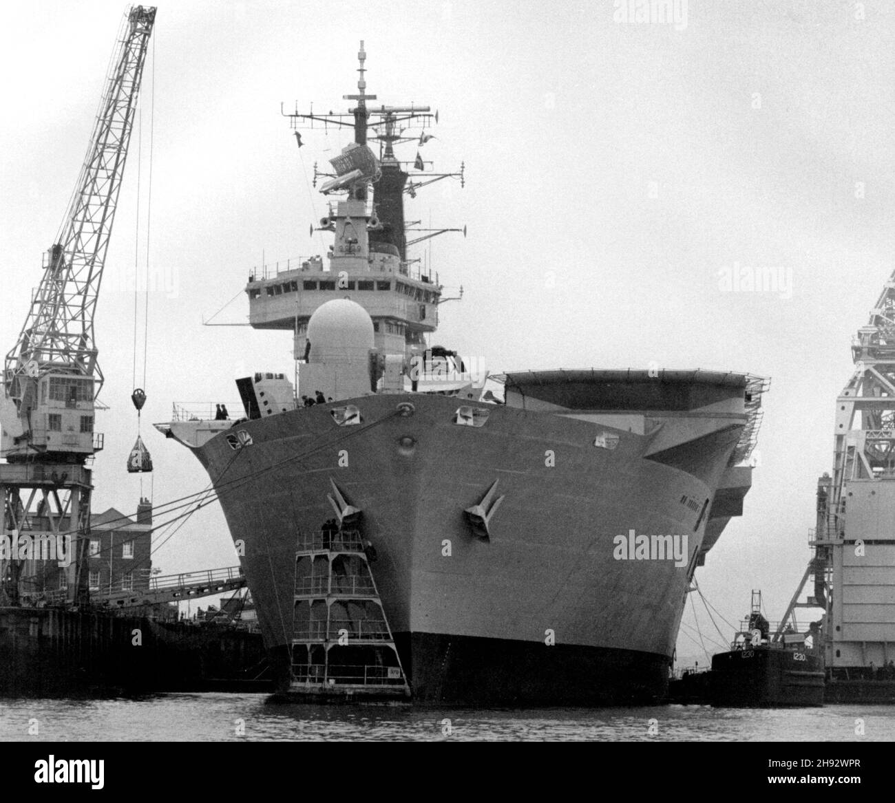 AJAXNETPHOTO. 1982. PORTSMOUTH,ENGLAND - INVINCIBLE PREPARES - THE CARRIER HMS INVINCIBLE SEEN AT PORTSMOUTH NAVAL BASE LOADING STORES IN PREPARATION FOR HER LONG VOYAGE SOUTH TO THE FALKLANDS ISLANDS. PHOTO:JONATHAN EASTLAND/AJAX REF:820304_2 Stock Photo