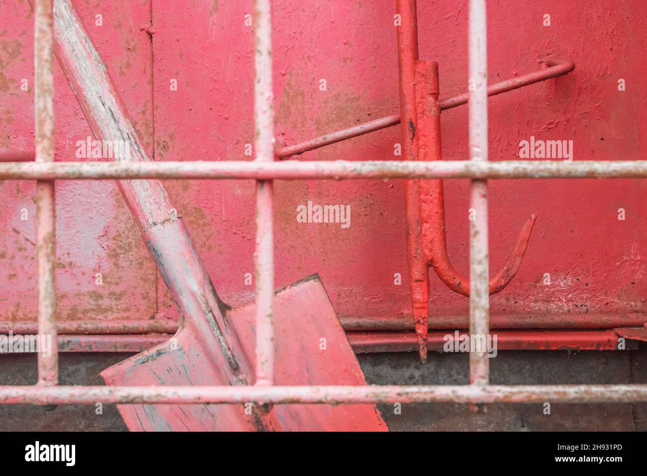Old red fire shovel equipment and tools to help safely extinguish fire. Stock Photo