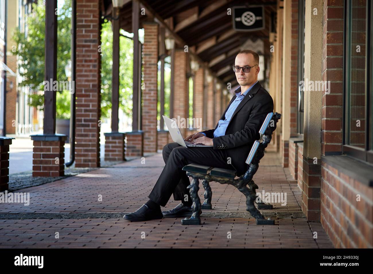 Successful businessman in a business suit working on his laptop outdoors Stock Photo