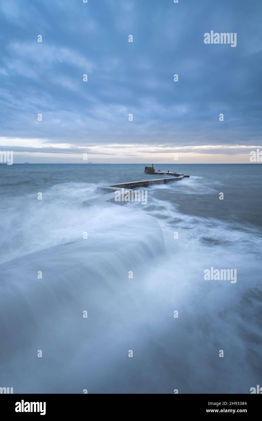 Waves crashing over the iconic zig-zag breakwater at St Monans harbour ...