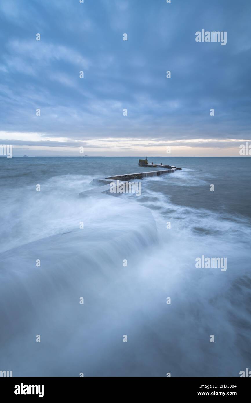 Waves crashing over the iconic zig-zag breakwater at St Monans harbour in the East Neuk of Fife, Scotland, UK. Stock Photo