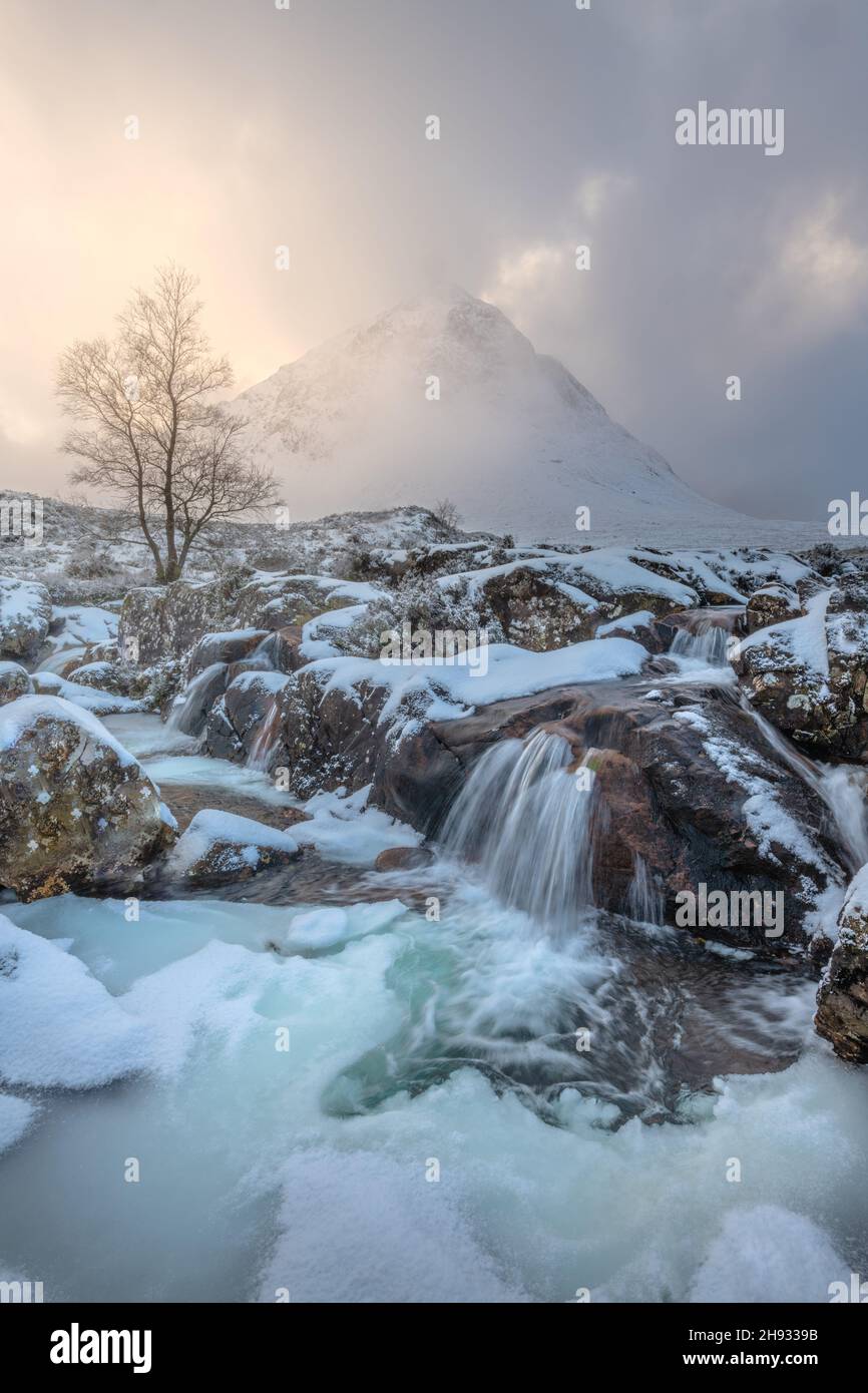 The frozen River Coupall flows past Stob Dearg (the prominent peak on Buachaille Etive More) on a wintery day in Glencoe, Scotland, UK. Stock Photo