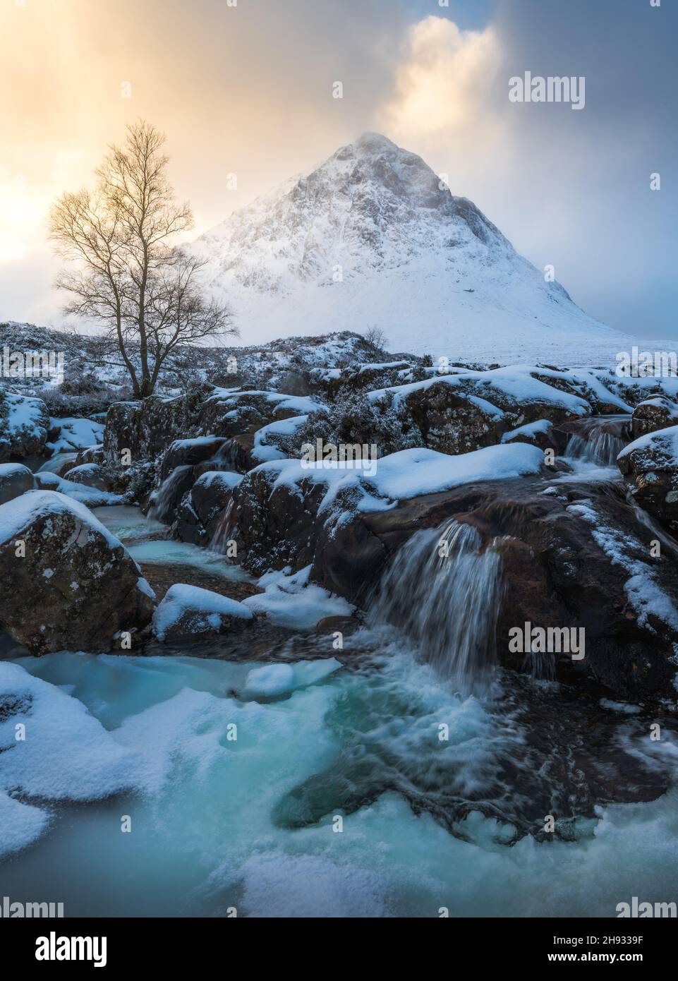 The frozen River Coupall flows past Stob Dearg (the prominent peak on Buachaille Etive More) on a wintery day in Glencoe, Scotland, UK. Stock Photo