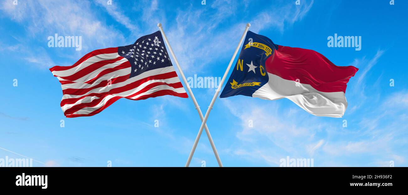 two flags of USA and state of North Carolina waving in the wind on ...
