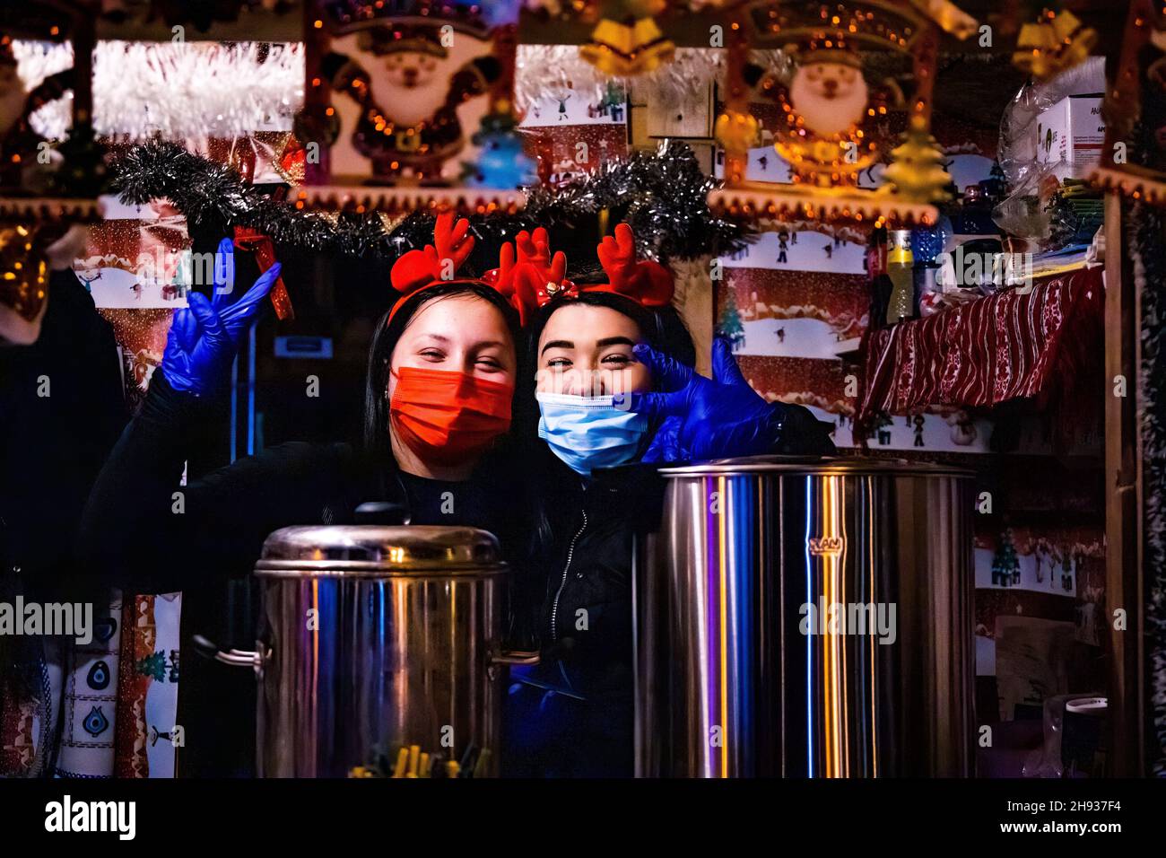 Bucharest, Romania. 3rd Dec. 2021. Two girls from a shop that sells mulled wine and some traditional romanian food Stock Photo