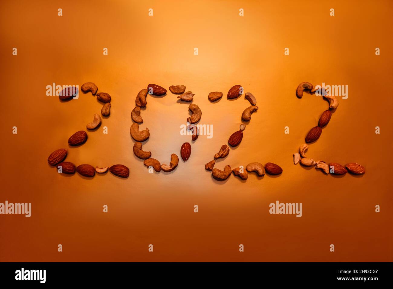 New year 2022. Number 2022 is lined with nuts on gold background.  Stock Photo