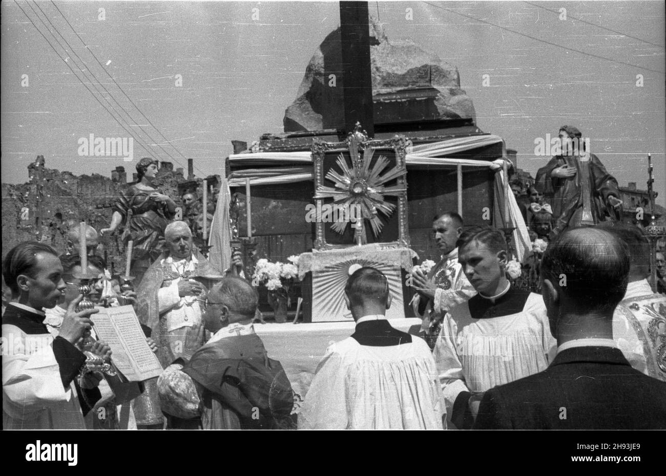 Warszawa, 1947-06-05. Procesja Bo¿ego Cia³a przed o³tarzem w miejscu kolumny Zygmunta III Wazy na placu Zamkowym. Nz. ksi¹dz odczytuje Ewangeliê na cztery strony œwiata, z lewej strony o³tarza kardyna³ August Hlond.  ps/gr  PAP      Warsaw, June 5, 1947. Corpus Cristi procession at the altar in the place of the Zygmunt III Waza Column on the Zamkowy Square. Pictured: a priest reads Gospel to the four cardinal points, Cardinal August Hlond (left).   ps/gr  PAP Stock Photo