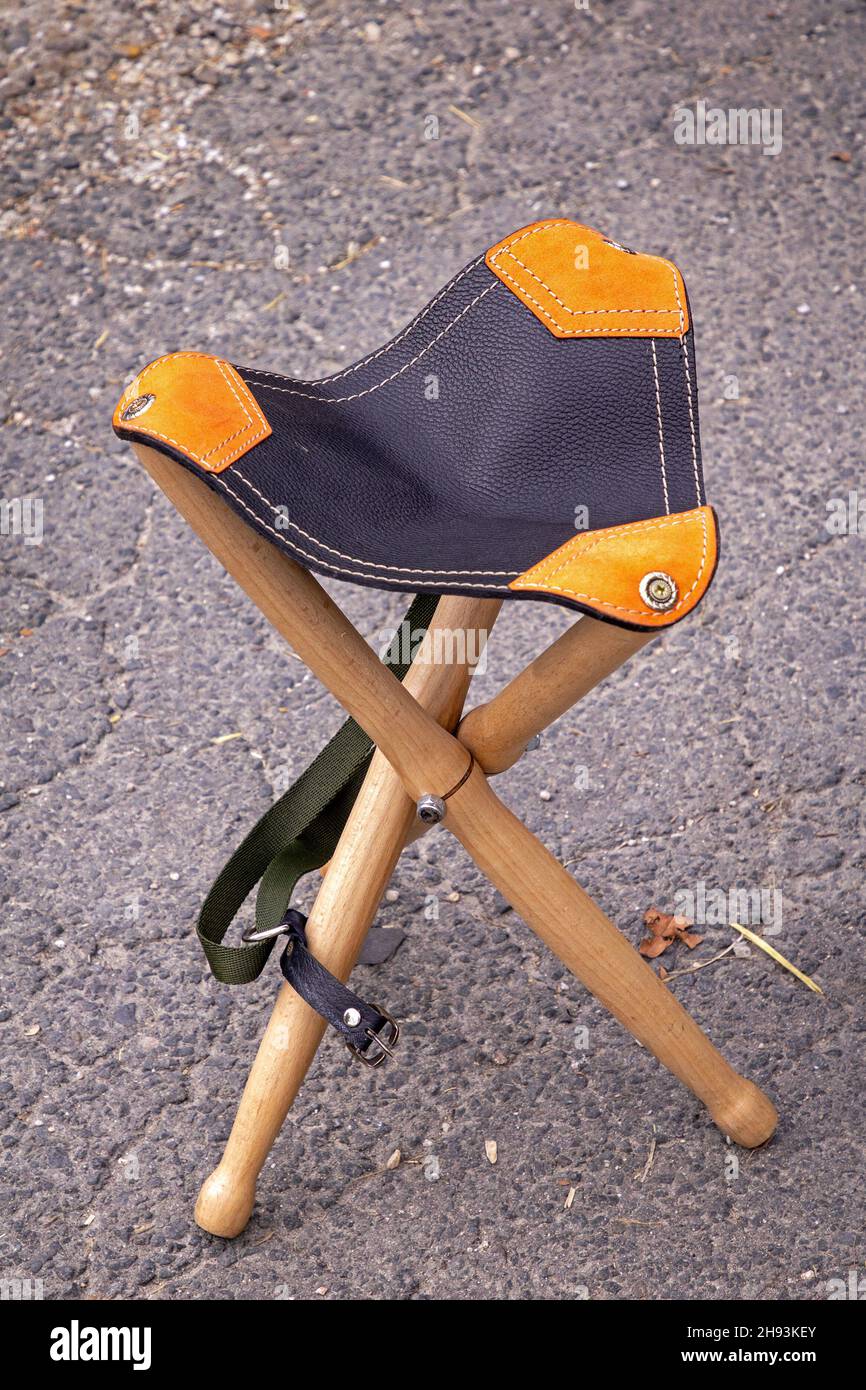 Small foldable tripod fishing stool used while camping Stock Photo