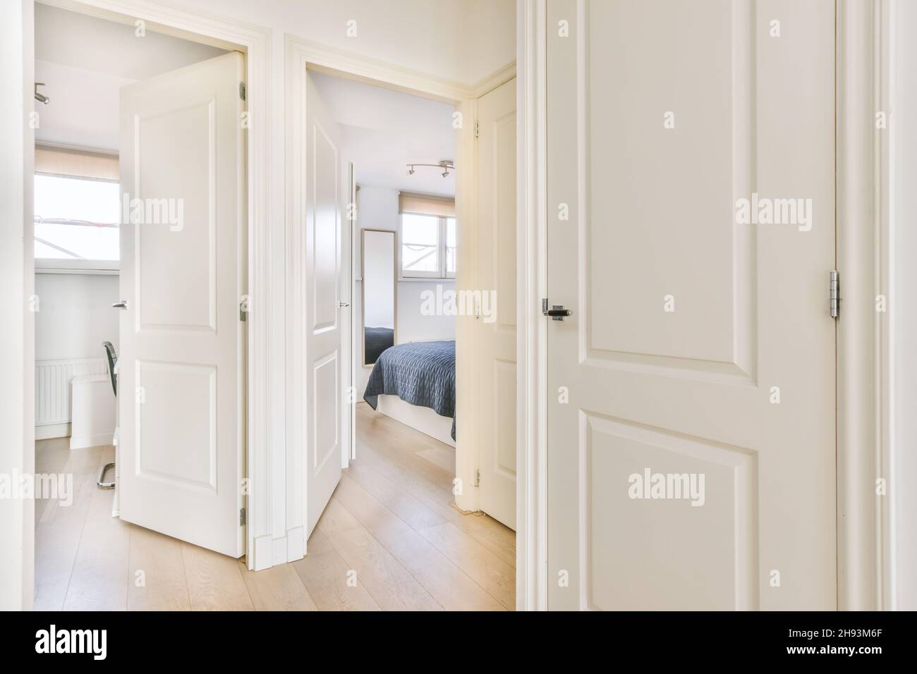 Luxurious hallway with many doors and an open door leading to the