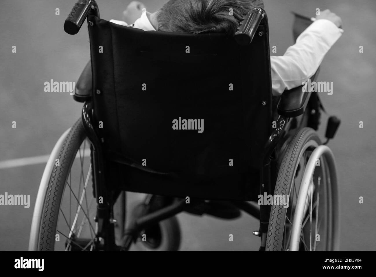 Shallow depth of field (selective focus) image with details of an ill disabled young boy in a wheelchair. Stock Photo