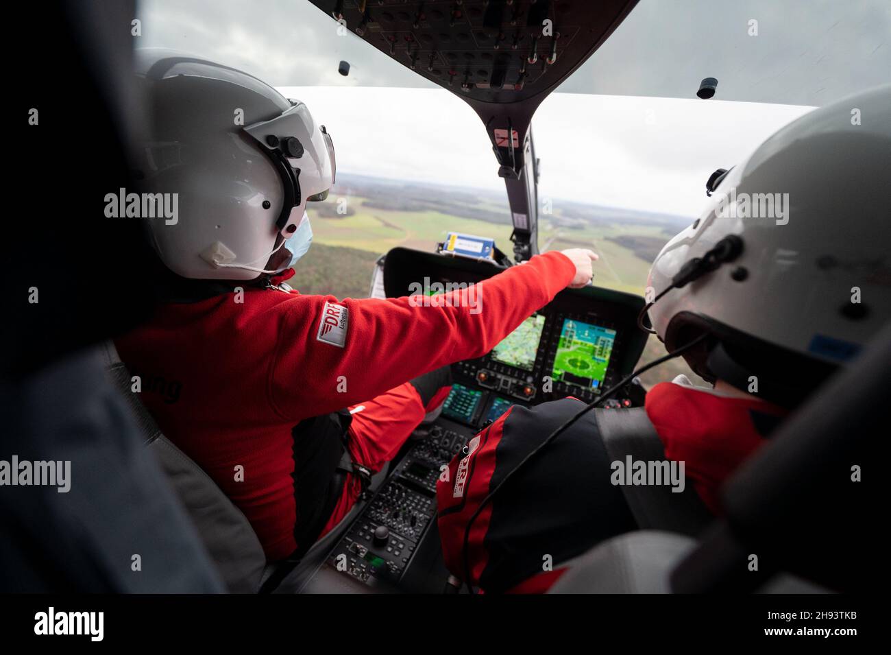 02 December 2021, Bavaria, --: Thomas Roth (r), DRF Luftrettung pilot, sits with emergency paramedic Georg Berg during a mission in the DRF rescue helicopter Christoph 51. During the mission, the DRF transported a patient who did not have Covid-19 in the DRF rescue helicopter Christoph 51 from the intensive care unit of the Hohenlohe Hospital to the intensive care unit of a rehabilitation clinic in Bavaria. Covid 19 patients are not the only ones who are now transported from one hospital to another by helicopter. In order to create capacity in the intensive care units, other patients are also Stock Photo