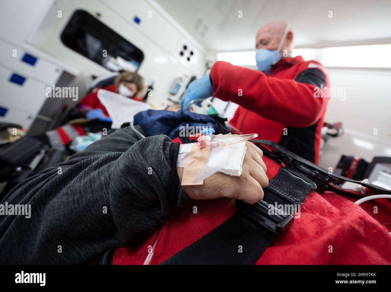 02 December 2021, Baden-Wuerttemberg, Öhringen: During a mission, emergency paramedic Georg Berg cares for a patient who is being transported in an ambulance from Hohenlohe Hospital to the DRF rescue helicopter Christoph 51, which had landed near the hospital. During the mission, the DRF transported a patient who did not have Covid-19 in the DRF rescue helicopter Christoph 51 from the intensive care unit of the Hohenlohe hospital to the intensive care unit of a rehabilitation clinic in Bavaria. Covid 19 patients are not the only ones who are now transported from one hospital to another by heli Stock Photo