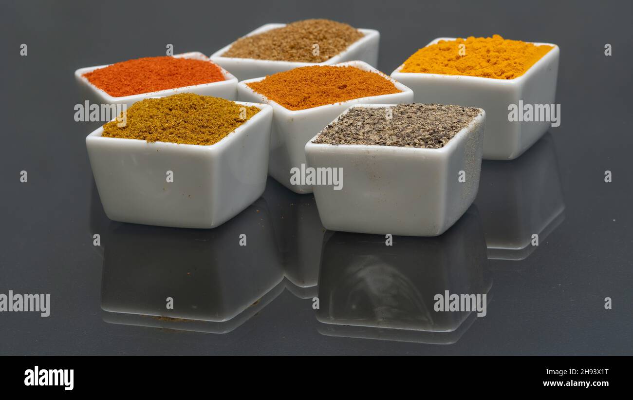 Assortment of powder spices in bowls. Selective focus. Chilli, turmeric, pepper, curry powder etc.. Stock Photo
