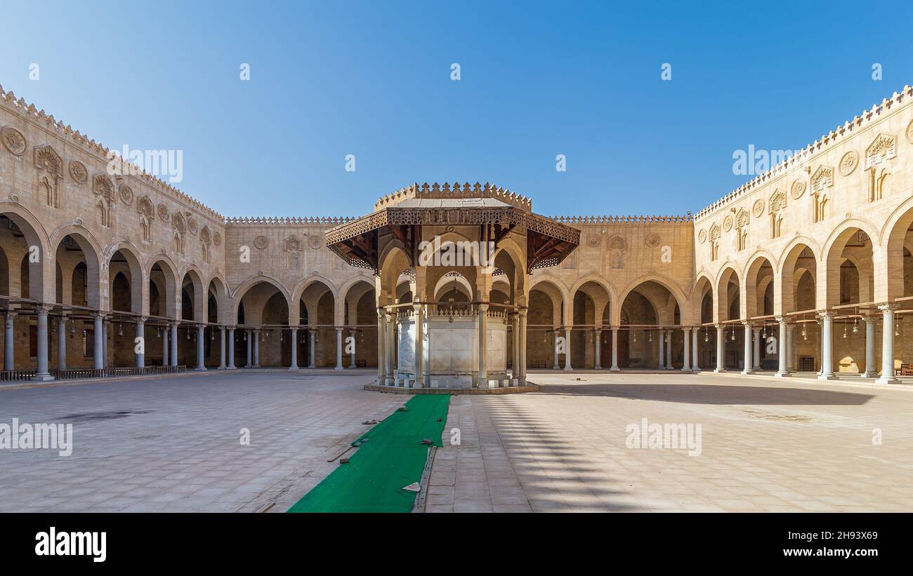 Ablution fountain mediating the courtyard of public historic mosque of Sultan al Muayyad, with background of arched corridors surrounding the courtyard, Cairo, Egypt Stock Photo