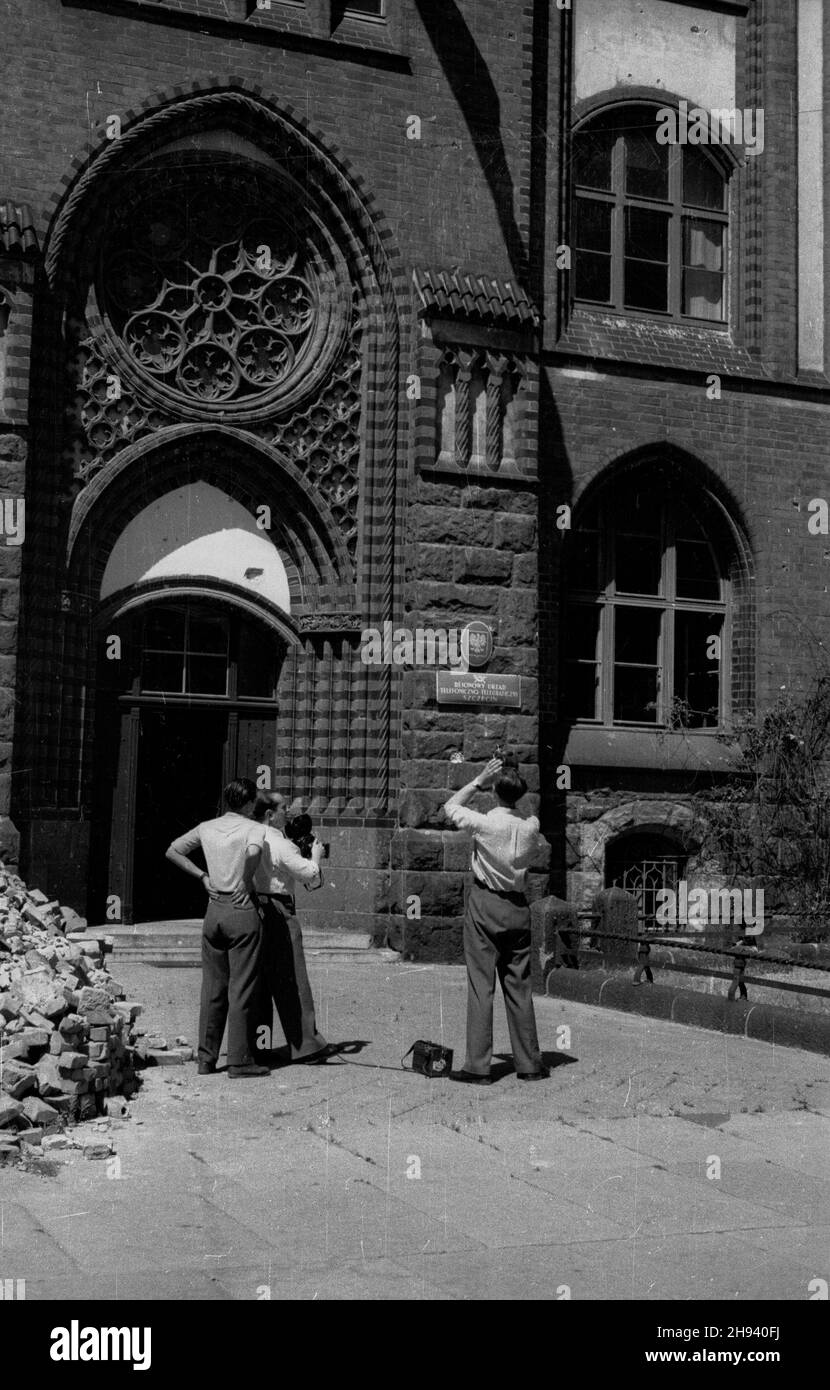 Szczecin, 1947-06-29. Operatorzy Polskiej Kroniki Filmowej filmuj¹ neogotycki gmach Rejonowego Urzêdu Telefoniczno-Telegraficznego. Z kamerami: z prawej Bogus³aw Lambach, z lewej W³adys³aw Forbert. po/mgs  PAP      Szczecin, June 29, 1947. Polish Newsreel cameramen filming the Neo-Gothic building of the District Telephone and Telegraph Office. With cameras: Boguslaw Lambach (right), Wladyslaw Forbert (left).  po/mgs  PAP Stock Photo