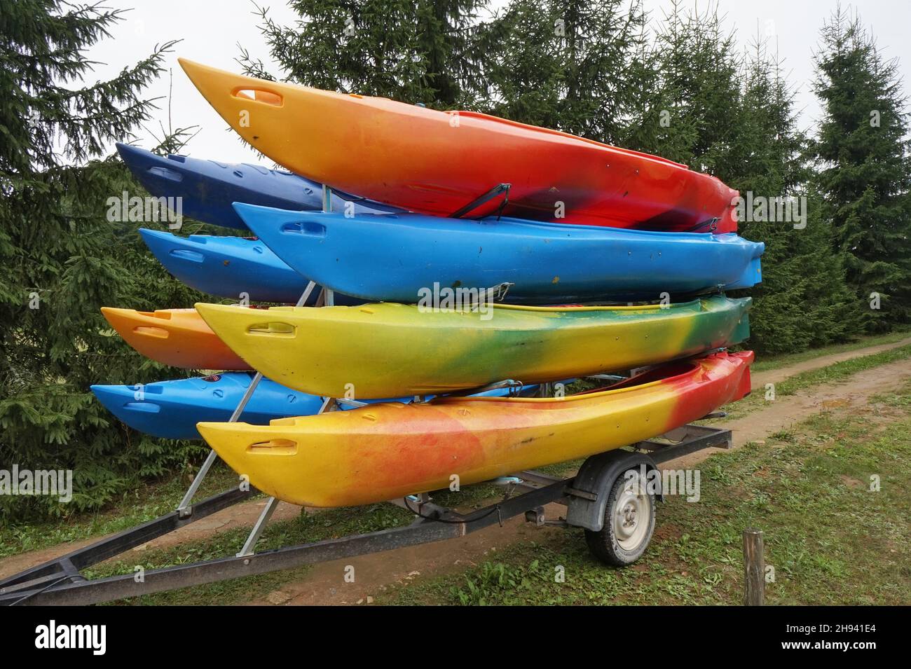 Plastic mass products kayaks of various colors on  track. Stock Photo