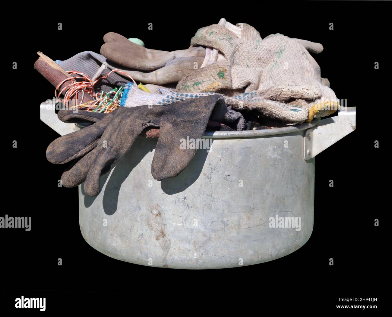 Dirty old work used gloves in a kitchen pot  isolated on black Stock Photo