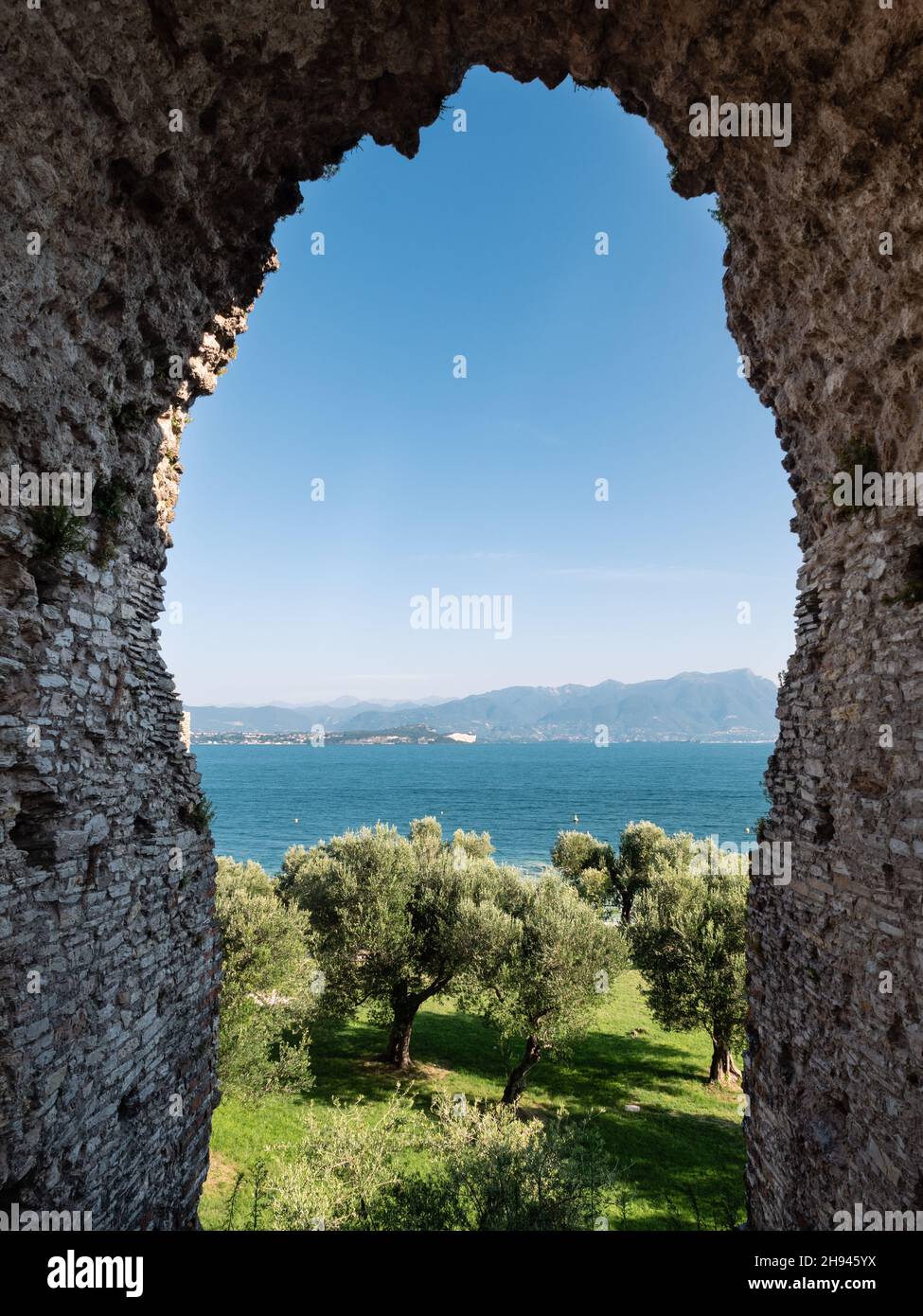 Lake Garda and Stone Arch of Grottoes of Catullus Roman Villa Ruins in Sirmione, Italy Stock Photo