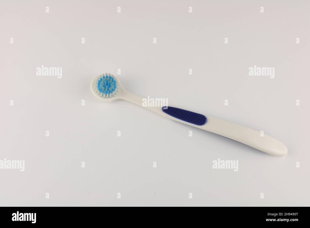 Tongue brush isolated on a plain background with copy space. Lingual papillae cleaning and oral hygiene concept Stock Photo