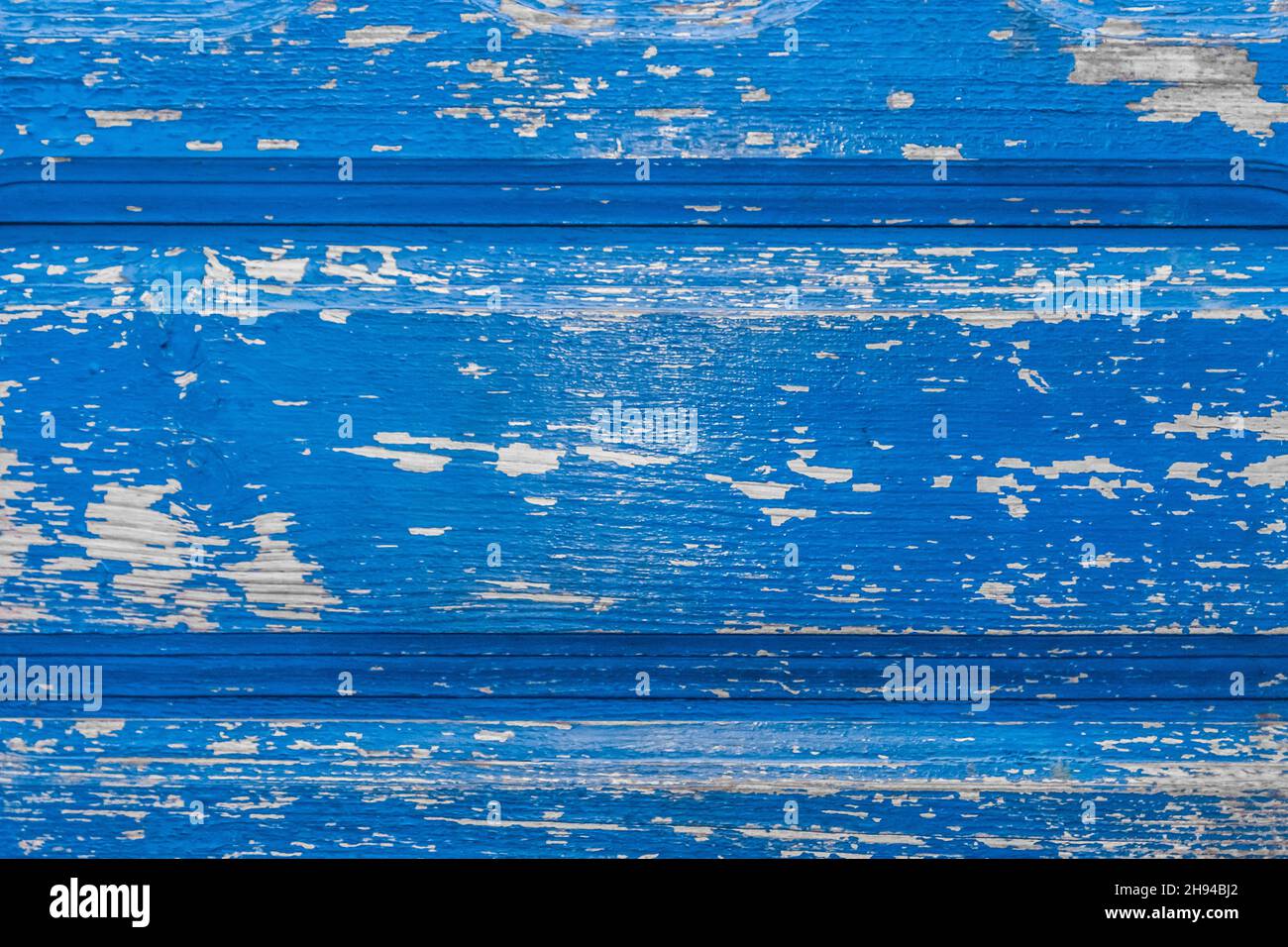 Blue old peeling paint from the surface of the wooden texture of the fence board weathered background. Stock Photo