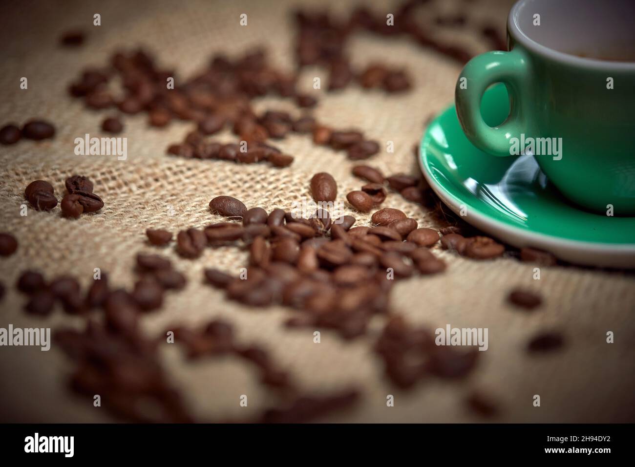 Close-up of aromatic and fragrant coffee beans and cup of coffee nicely arranged on the bag. Coffee, beverage Stock Photo