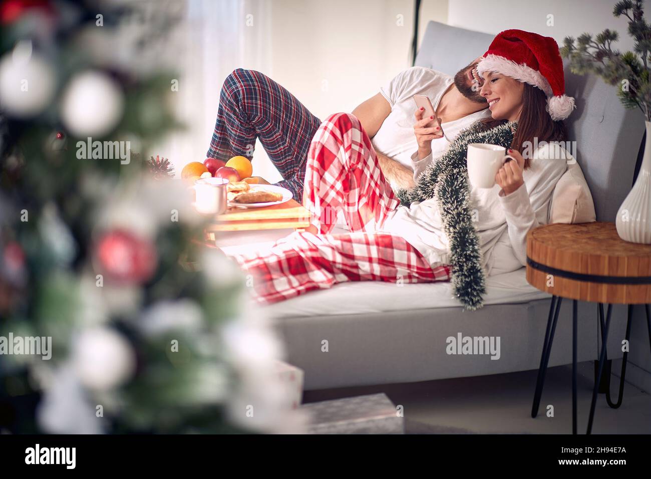 Men and smiling woman at Christmas morning texing mesage at the bed Stock Photo