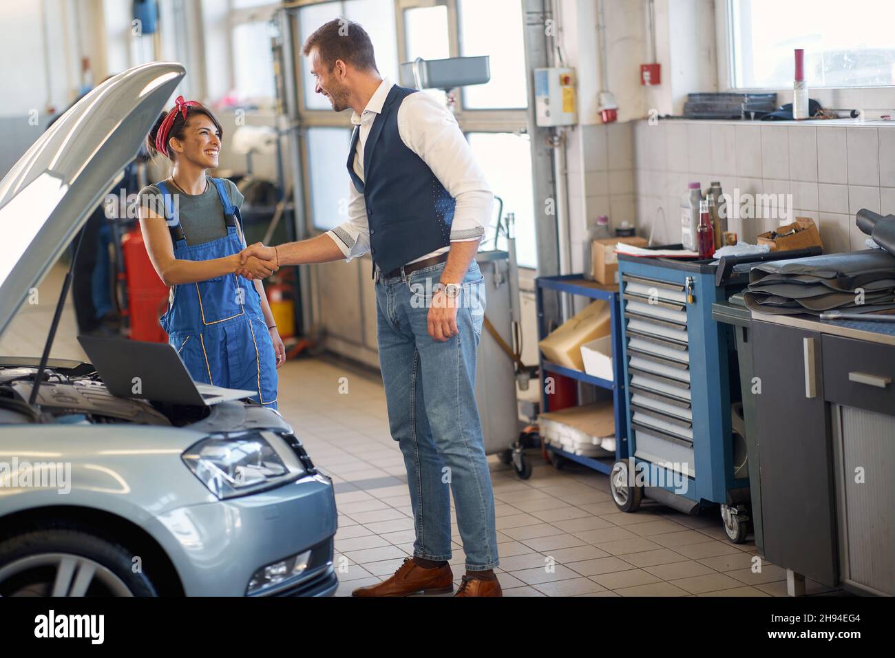 Woman mechanic communicates with the smiling client Stock Photo