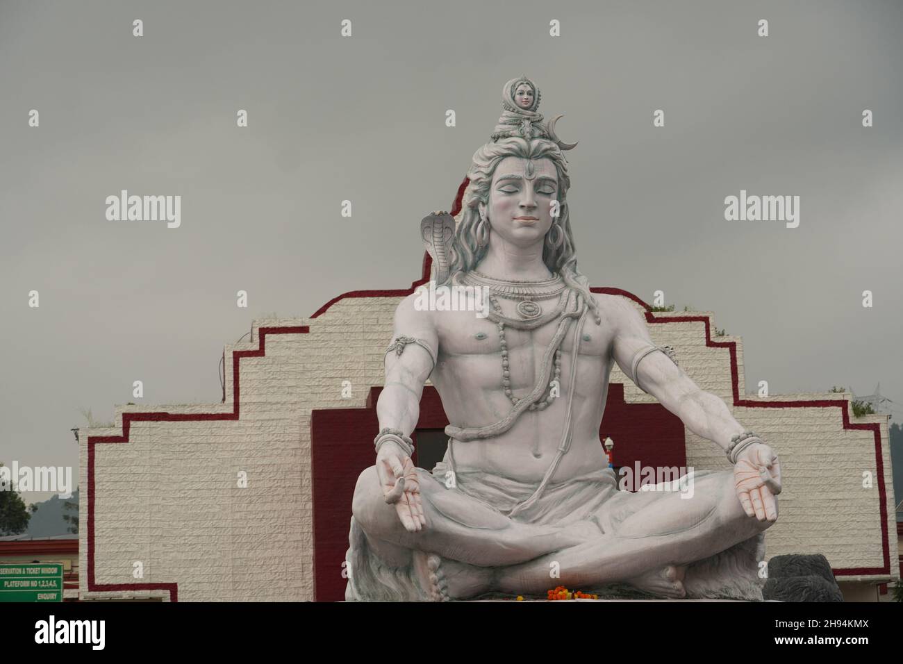 Hindu god Shiva sculpture sitting in meditation on Ganges river in Rishikesh, India, Stock Photo